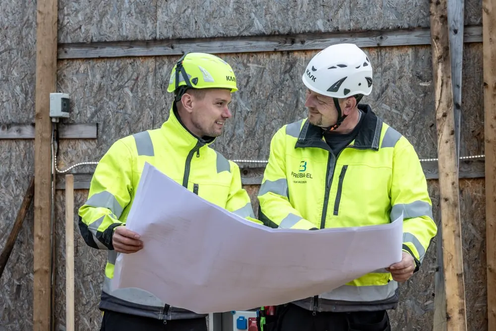 Elektriker gennemgår eltegninger sammen med kunden på pladsen