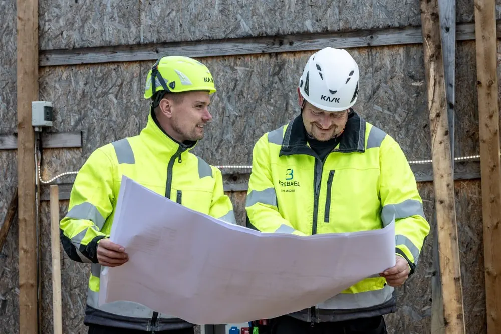 Elektriker gennemgår eltegninger sammen med kunden på pladsen