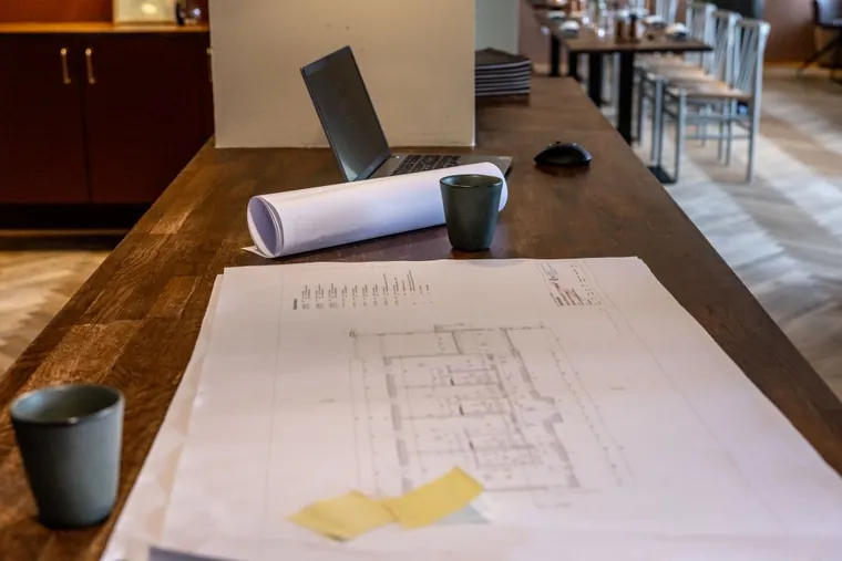 Montør og kunde kigger på el-plan foran byggeriet