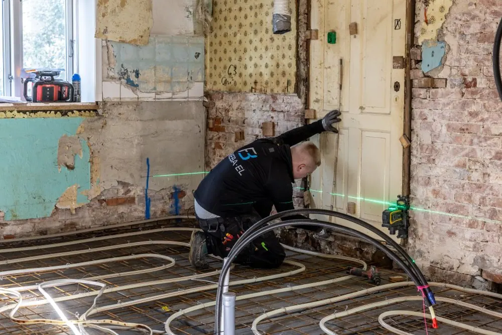 Elektriker riller vægge til nye el-installationer under renovering