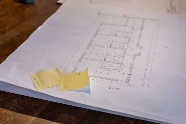Montør og kunde kigger på el-plan foran byggeriet