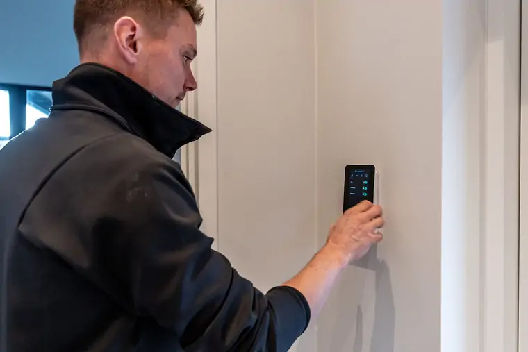 Elektriker betjener et smart home-panel på væggen